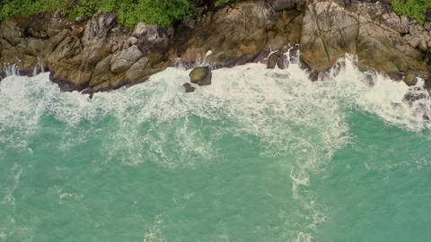 Aerial top view waves break on dark rocks near beach. Sea waves on the danger Stock Footage 150529827