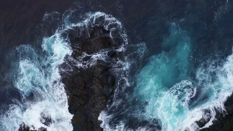 Aerial top view of waves break on rocks. Foaming and splashing Ocean surf. Waves Stock Footage 164917485
