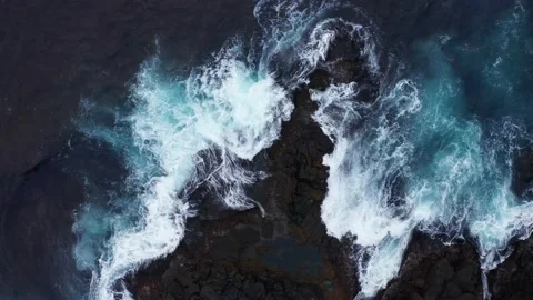 Aerial top view of waves break on rocks. Foaming and splashing Ocean surf. Waves Stock Footage 164917533