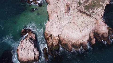 Aerial top view of waves break on rocks in a blue ocean. Stock footage. Sea 動画素材 165071596