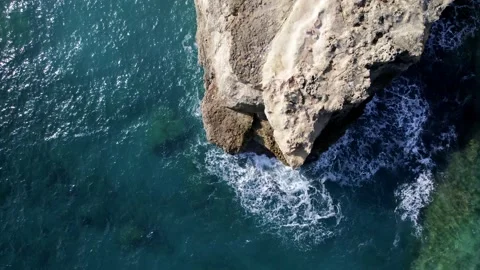 Aerial top view waves break on rocks in a blue ocean. Sea waves Video stock 168250892