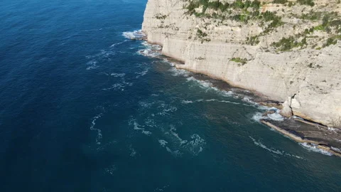 Aerial top view of waves break on rocks in a blue ocean. Sea waves on beautiful Stock Footage 176295515