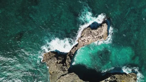 Aerial top view of waves break on rocks in a blue ocean. Sea waves on beach Stock Footage 270068197