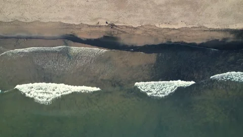 Aerial Top View Of Waves Reaching Beach With Two People Walking Stock Footage 170459968
