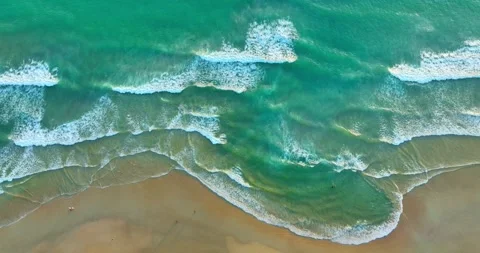 Aerial top view White waves froth in green sea water lapping the shore. 動画素材 244243939