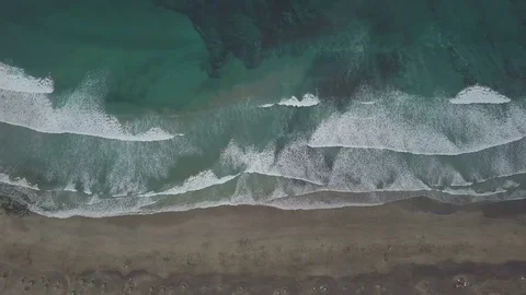 Aerial topdown footage of camera move right along the coastline with waves Stock Footage 85301996