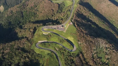 Aerial tops down curved zig zag mountain road in green mountain Japan landscape Stock Footage 323343907