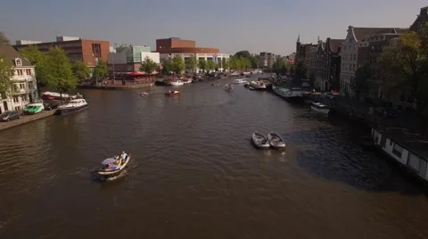 Aerial. Tour boats on water channel in Amsterdam. Camera moves back. 4K Stock Footage