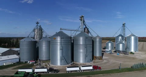 Aerial Towards Large Silos Complex Rising Above The Trucks and Over Large Silos Stock Footage 199892266