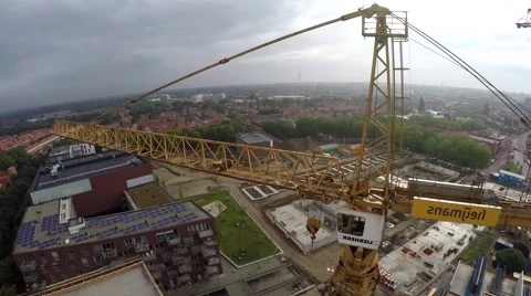 Aerial tower building crane through construction site solar panels on rooftop 4k Stock Footage 52401701