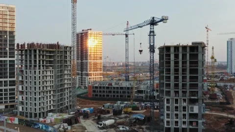 Aerial tower cranes working on construction site. Sunlight reflected in glass Stock Footage 152530576