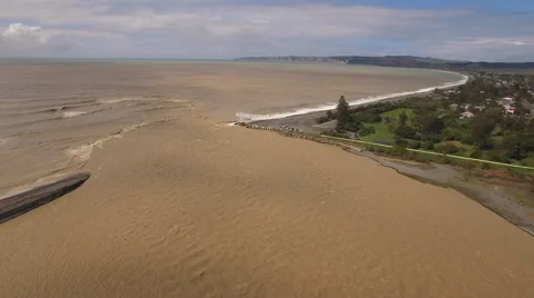 Aerial track down flooded river towards  sea Stock Footage 55868611