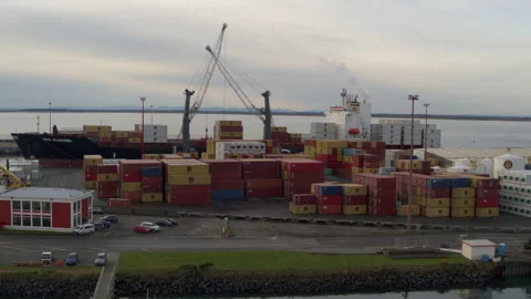 Aerial tracking drone shot of container ship being unloaded Stock Footage 155376083