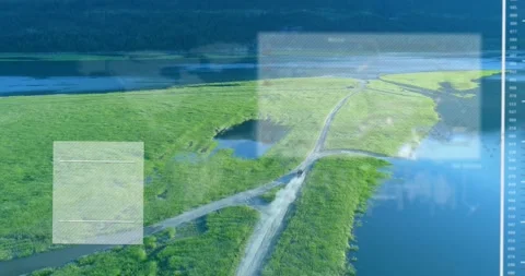 Aerial tracking marsh spit road, vehicle appearing triggers HUD showing pond and Stock Footage 333900680
