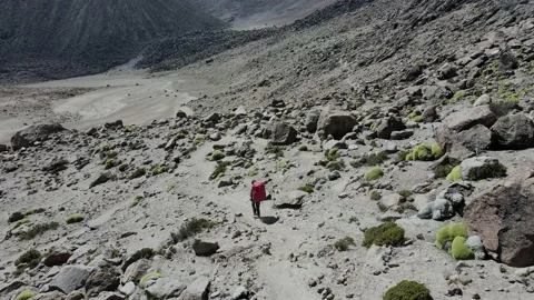 Aerial tracking of one on an expedition in the middle of the high mountains Video stock 202346445