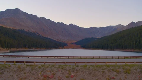 Aerial - Tracking parallel to road with mountains in background Stock-Footage 95410093