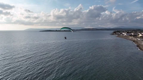 Aerial tracking of a paramotor flying over the sea with a drone Video stock 266389790