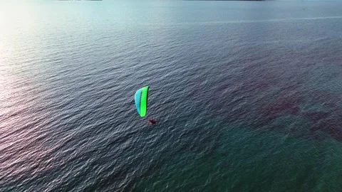 Aerial tracking of a paramotor flying over the sea with a drone Stock Footage 266390467