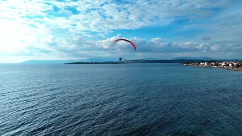 Aerial tracking of a paramotor flying over the sea with a drone Stockbeeldmateriaal 266391373