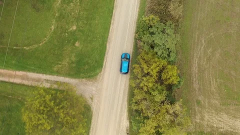 Aerial Tracking Shot of a Blue SUV Driving Down a Country Road Stock Footage 118090971