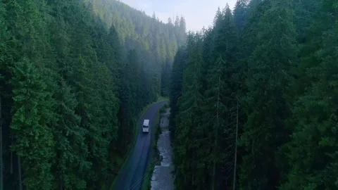 Aerial tracking shot of bus navigating curvy mountain Stock Footage 326936923