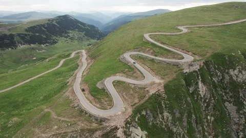 Aerial tracking shot of a car driving on the Transalpina road Stock-Footage 340647565