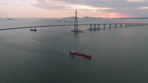 Aerial Tracking Shot of Cargo Ship Passing Incheon Bridge at Sunset Stock Footage 344694409