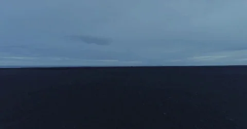 Aerial tracking shot of desolate barren black sand desert at night Stockbeeldmateriaal 79857344