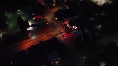 Aerial tracking shot of driving fire truck on street of american town at night Video stock 308347470