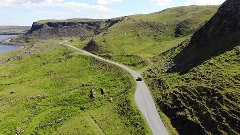 Aerial tracking shot following car on a mountain road on the Isle of Skye Stock Footage