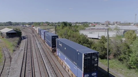 Aerial tracking shot of freight train passing quickly through American town (4K) Stock Footage 127763259