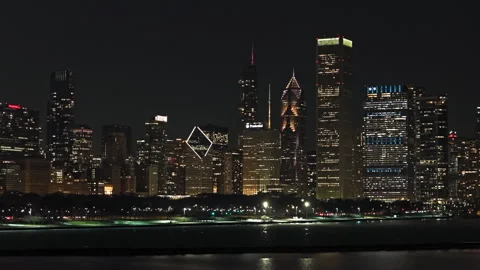 Aerial tracking shot in front of parks and illuminated Chicago Loop skyscrapers Stock Footage 333184813