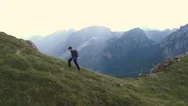 Aerial - Tracking Shot Of A Hiker Walking Uphill On The Edge Of A Cliff Stock Footage