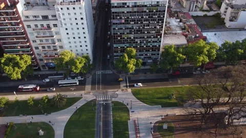 Aerial tracking shot of many buses driving on road beside high-rise Stock Footage 163952743