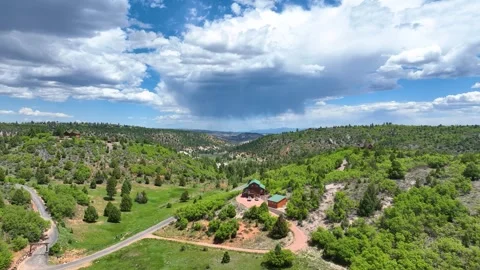Aerial Tracking Shot Over Mountain Cabin Lush Forest and Storm Cloud Motion Stock Footage 339811038
