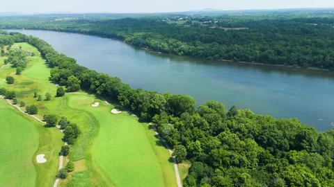 Aerial Tracking Shot Over Riverfront Golf Course on Sunny Day Stock Footage 346185312