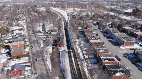 Aerial Tracking Shot of Passenger Train in Montreal Residential Area Stock Footage 307723336
