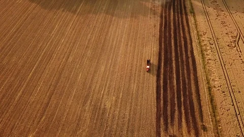 Aerial tracking shot of red tractor driving on a field in summer Stock Footage 119824187