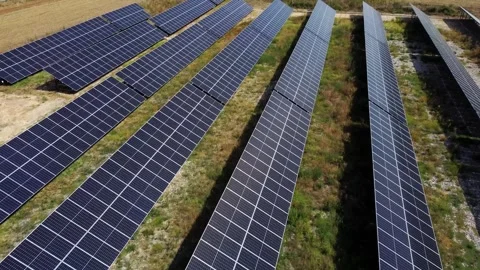 Aerial tracking shot of solar panel rows sweeping over grassy solar farm fi.. Stock Footage 335801839