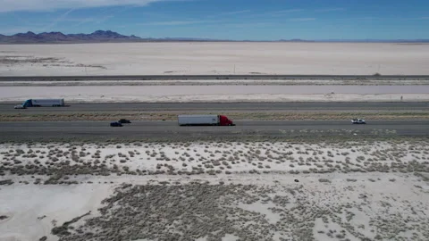 Aerial tracking shot of traffic on an interstate highway through the desert Stock Footage 238354735