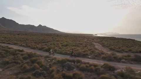 Aerial Tracking Shot of Two Cyclists Riding Electric Bikes on Dirt Trail at 스톡 동영상 345101665