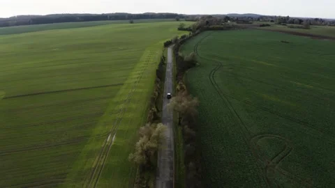 Aerial tracking shot of a van along northern German fields Stock Footage