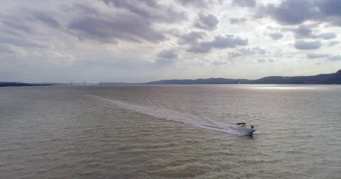 (Aerial) Tracking Small Boat on River on Overcast Day Stock Footage 83793903
