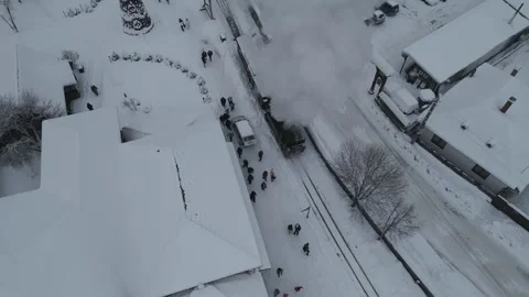 Aerial tracking of steam train through snowy village Stock Footage 341764383