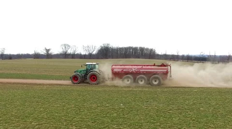 Aerial Tracking Tractor Driving Down Dirt Field Lane leaving Cloud of Dust Stock-Footage 61175782
