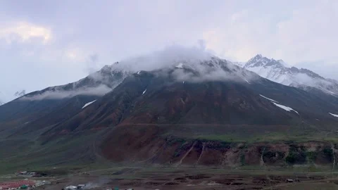 Aerial Tracking View of Low Hanging Clouds over a High-Altitude Alpine Valley Видео 332978410