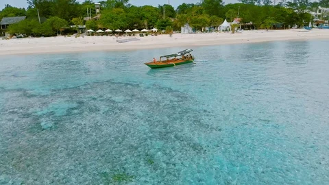 Aerial tracking view over local fishing boat on Gili Air island. Stockbeeldmateriaal 105386955