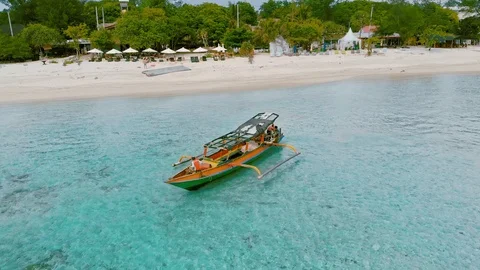 Aerial tracking view over traditional local fishing boat on Gili Air island Stockbeeldmateriaal 105805331