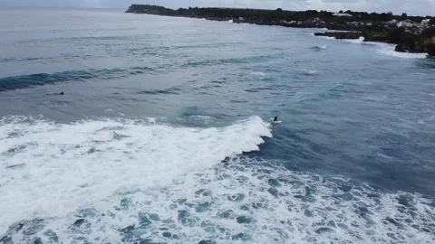 Aerial Tracking View of Surfer with Surfboard on Wave, Caribbean Island Surfing  Stock Footage 142335673