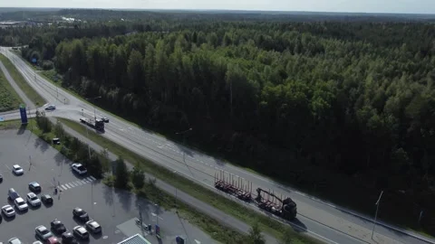 Aerial tracks empty logging truck with picker on flatbed trailer Stock Footage 259741854